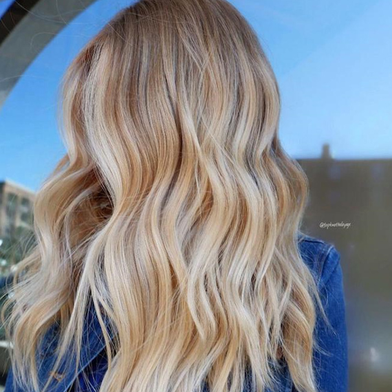Frau mit butterblondem Haar, kreiert mit Wella Professionals.