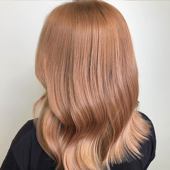 Foto des Hinterkopfes einer Frau mit erdbeerblondem Haar, kreiert mit Wella Professionals.