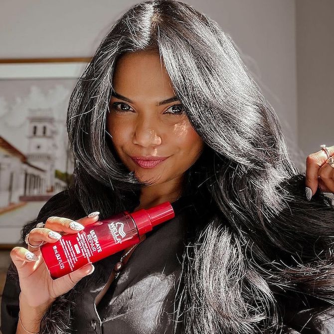 Model with long, dark, smooth hair holds up ULTIMATE REPAIR Miracle Hair Rescue.
