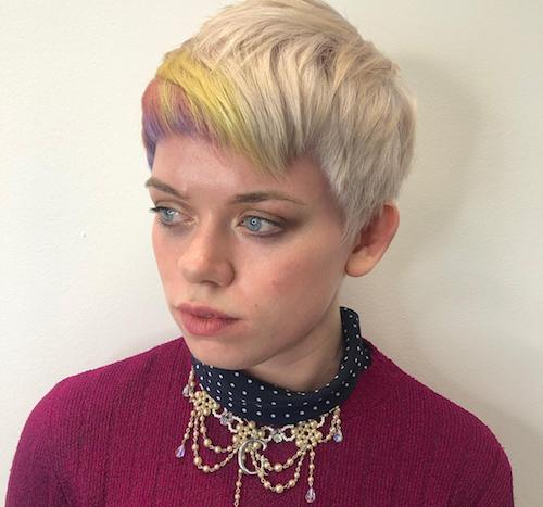 Woman with short ice blonde hair with rainbow fringe