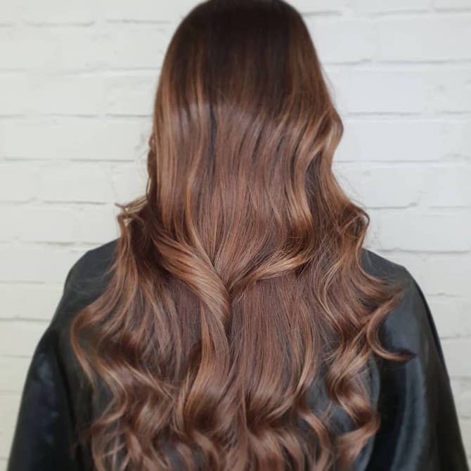 Hinterkopf einer Frau mit langem, groß gelocktem, brünettem Haar, kreiert mit Wella Professionals.
