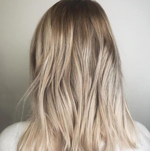 Foto des Hinterkopfes einer Frau mit blonden Babylights, kreiert mit Wella Professionals.