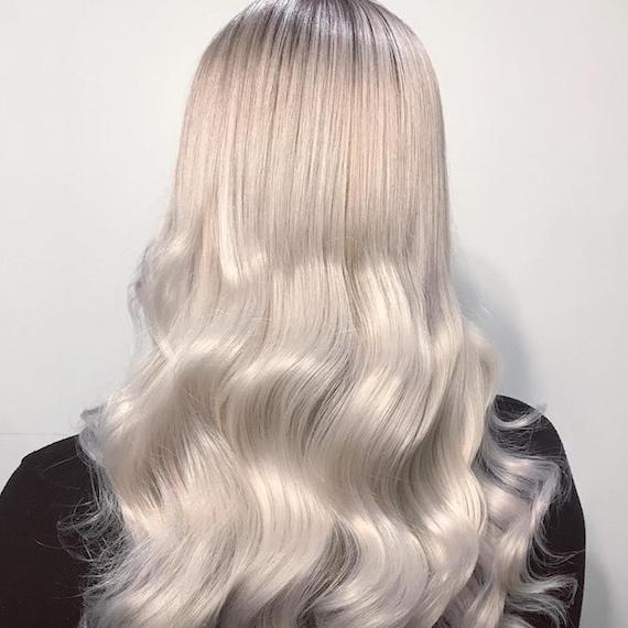 Foto des Hinterkopfes einer Frau mit langem eisblonden Haar, kreiert mit Wella Professionals.