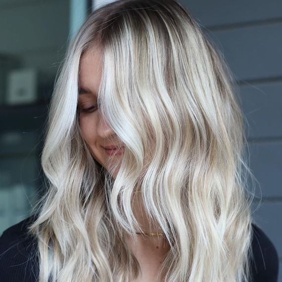 Model with type 2A wavy hair looks down.