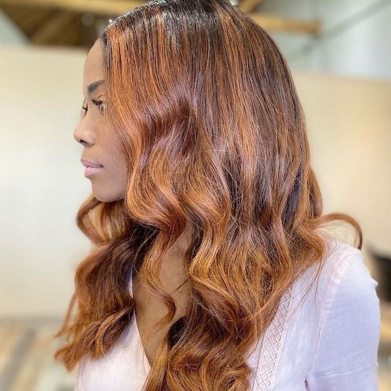 Model with dark brown hair and cinnamon red highlights.