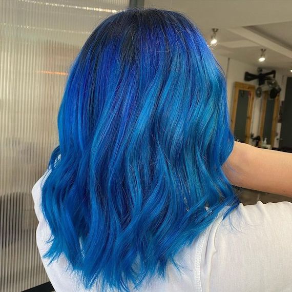 Hinterkopf einer Frau mit hellblauem, gewelltem Haar.