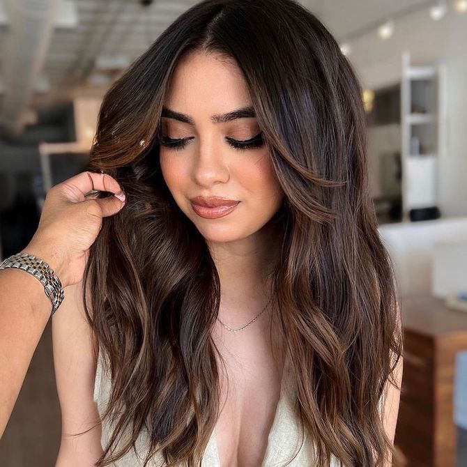 Model with long, dark hair styled in beachy waves.