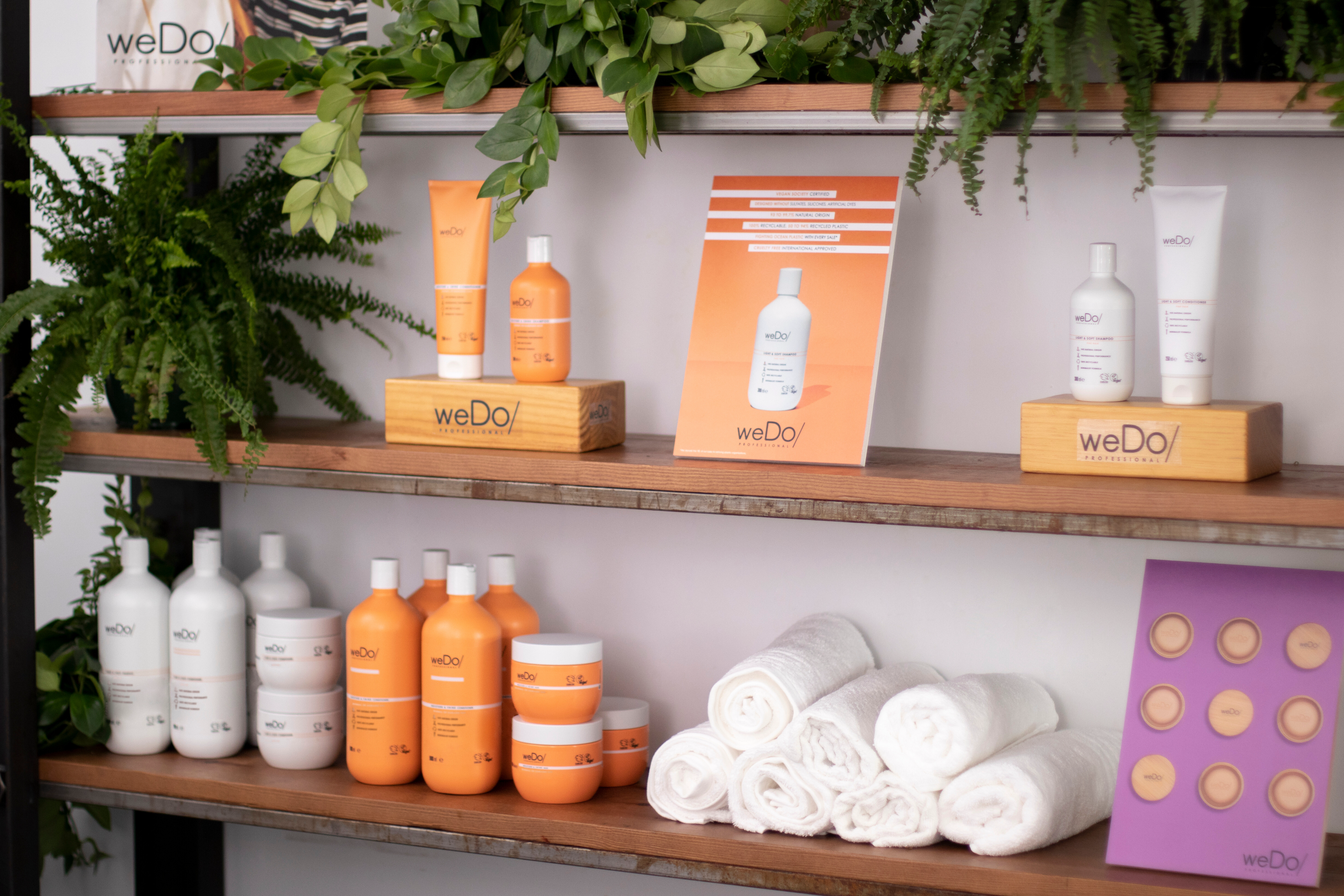 Mehrere nachhaltige Produkte von weDo/ Professional stehen in einem Regal im Friseursalon.