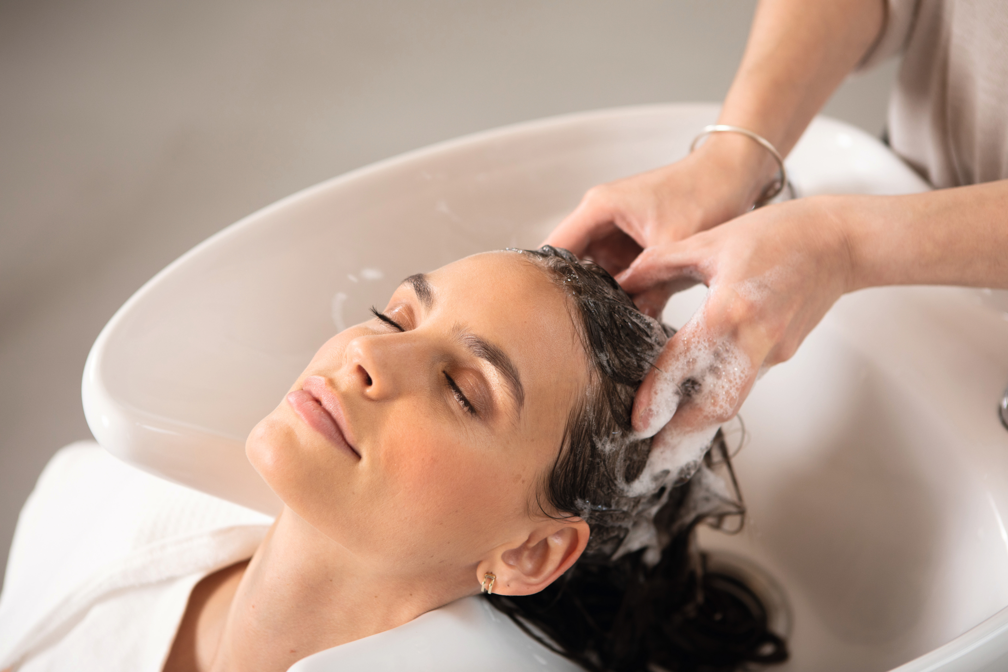 Frau im Friseursalon werden die Haare gewaschen.