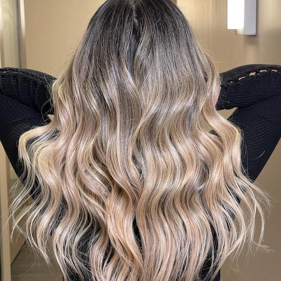Back of model’s head with beachy ash blonde ombre hair.