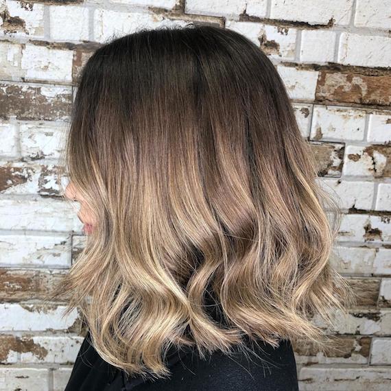 Side profile image of a woman with short hair and ash brown ombre hair color, created using Wella Professionals.