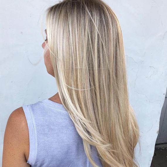 Back of woman’s head with long, straight, blonde hair and babylights, created using Wella Professionals.