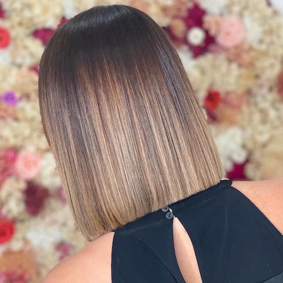 Hinterkopf einer Frau mit glatter, brünettem Balayage, kreiert mit Wella Professionals.
