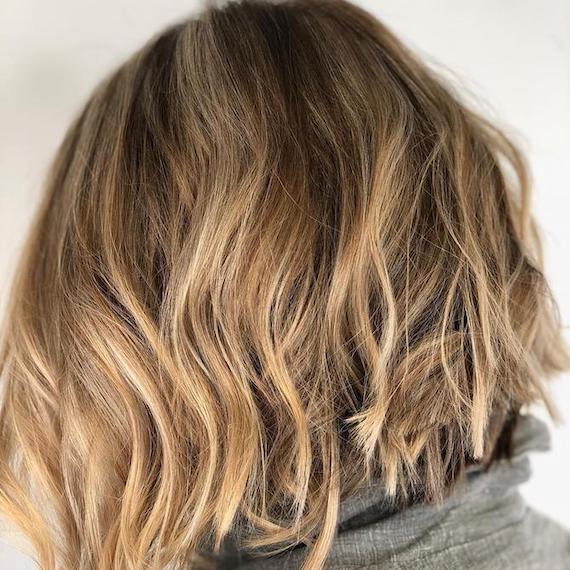 Hinterkopf einer Frau mit beachy blondem Balayage-Bob, kreiert mit Wella Professionals.