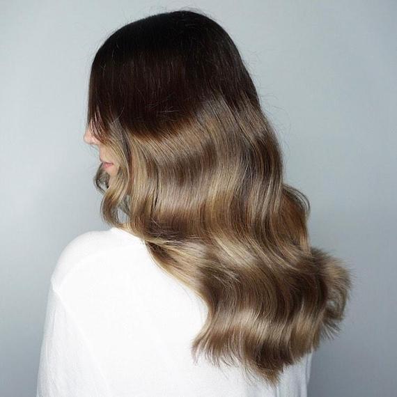 Model with long, wavy hair and dark brown balayage, created using Wella Professionals.