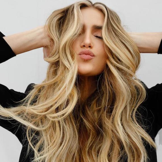 Woman facing camera with long, wavy, beachy hair, created using Wella Professionals.