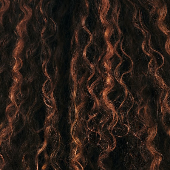 Nahaufnahme von lockigem, braunem Haar.