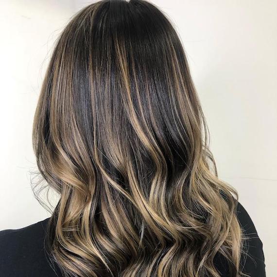 Hinterkopf einer Frau mit Balayage von Dunkelbraun zu Blond, kreiert mit Wella Professionals.