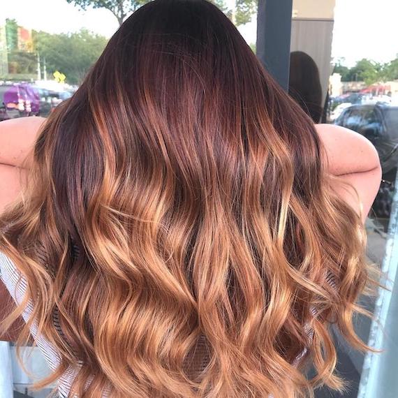 Hinterkopf einer Frau mit Balayage von Rotbraun zu Erdbeerblond, kreiert mit Wella Professionals.