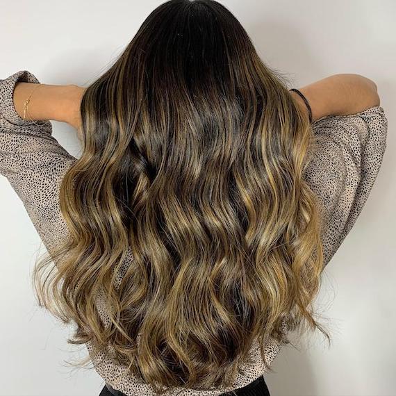 Hinterkopf einer Frau mit Balayage von Braun zu Dirty-Blonde, kreiert mit Wella Professionals.
