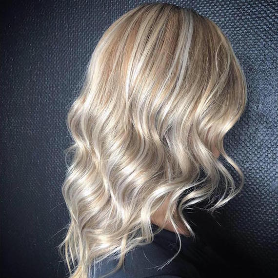 Seitenprofil einer Frau mit sandblonden Highlights, kreiert mit Wella Professionals.