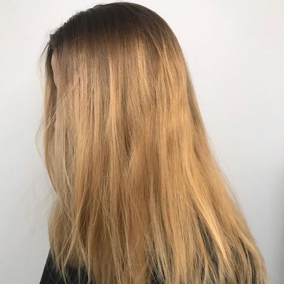 Seitenprofil einer Frau mit blondem Haar und dunklen Ansätzen.