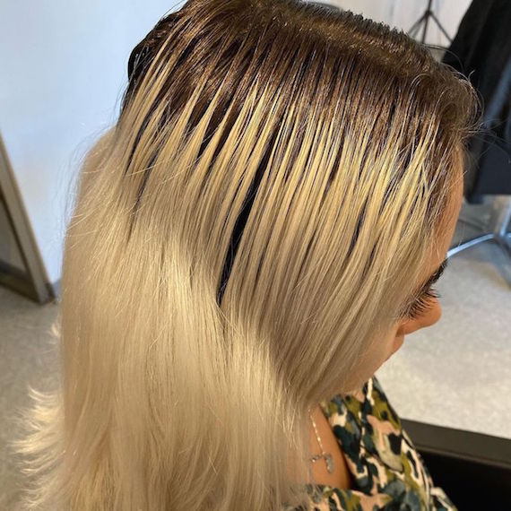 Seitenprofil einer Frau mit blondem Haar und dunklen Ansätzen.