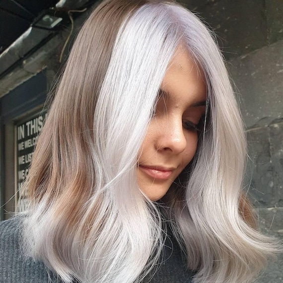 Model with straight, shiny, brown and blonde colour block hair.