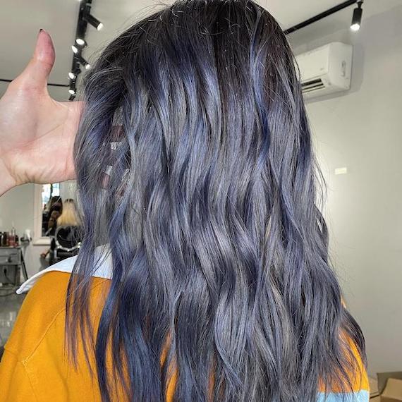Back of woman’s head with tousled navy blue hair, created using Wella Professionals.