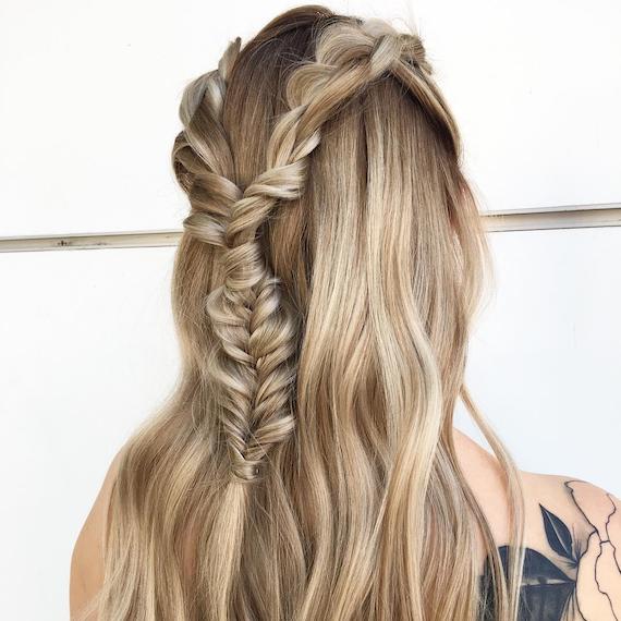 Back of woman’s head with wavy, blonde hair in a half-up braid, created using Wella Professionals.