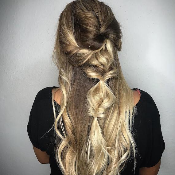 Hinterkopf einer Frau mit blondem, gedrehtem Half-up Zopf, kreiert mit Wella Professionals.