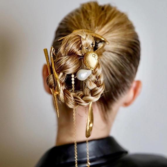 Back of woman’s head with blonde braided bun, created using Wella Professionals.