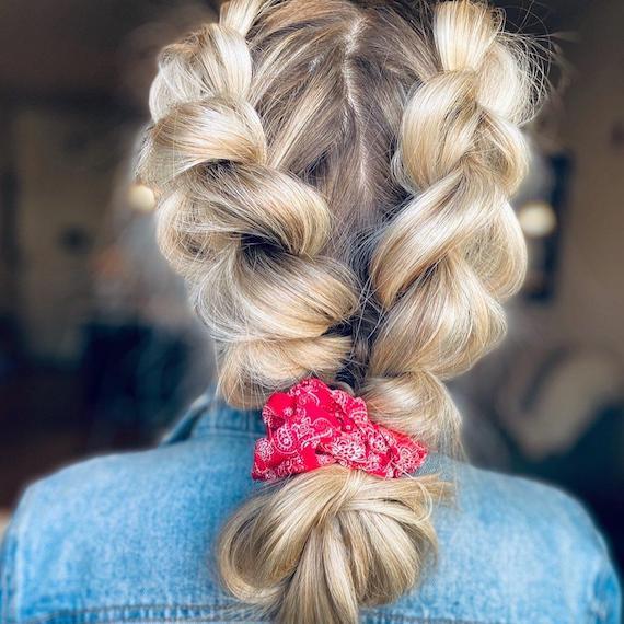 Back of woman’s head with chunky blonde double Dutch braid, created using Wella Professionals.