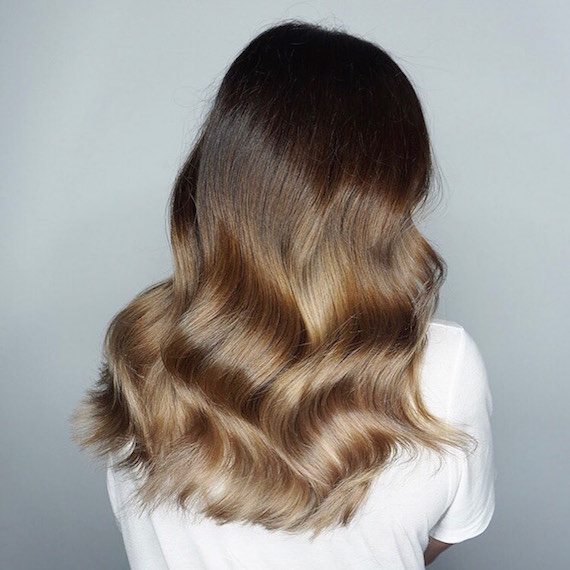 Back of woman’s head with wavy hair and brunette balayage, created using Wella Professionals.