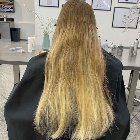 Back of woman’s head with long brassy hair.