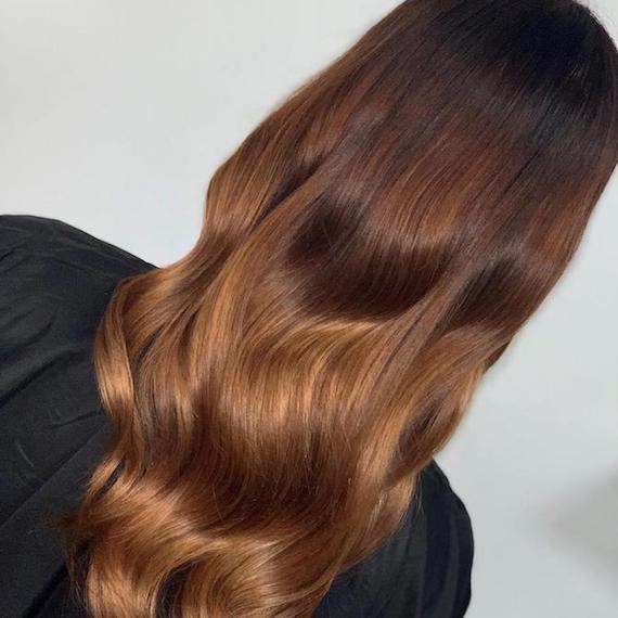 Hinterkopf einer Frau mit langem, gewelltem, schokoladenbraunem Haar, kreiert mit Wella Professionals.