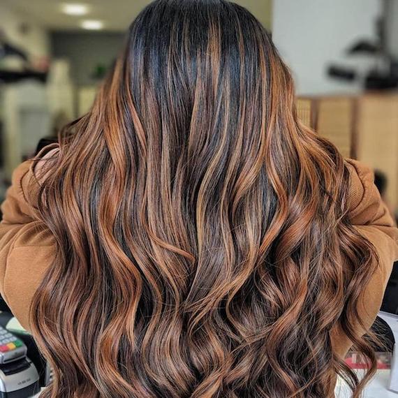 Long, wavy brunette hair that's been coloured using the balayage technique to lighten the mid-lengths and ends