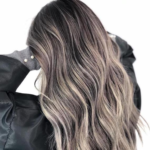 Hinterkopf einer Frau mit langem, gewelltem, graubraunem Haar, kreiert mit Wella Professionals.