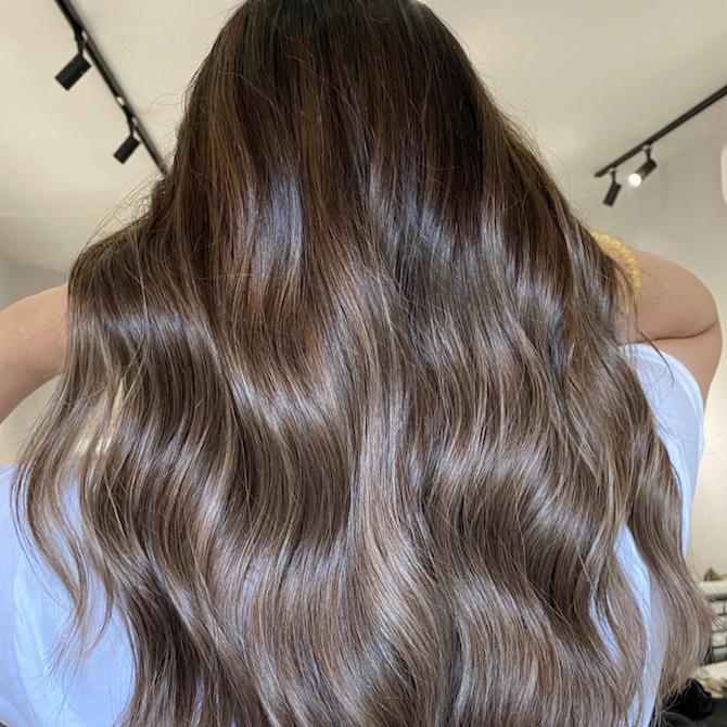 Back of woman’s head with long, wavy, dark brown ombre hair, created using Wella Professionals.