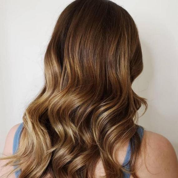 Hinterkopf einer Frau mit hellbraunem Haar und Balayage, kreiert mit Wella Professionals.