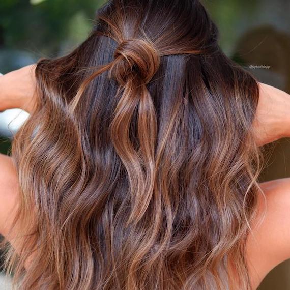 Back of woman’s head with wavy hair and a toffee balayage, created using Wella Professionals.