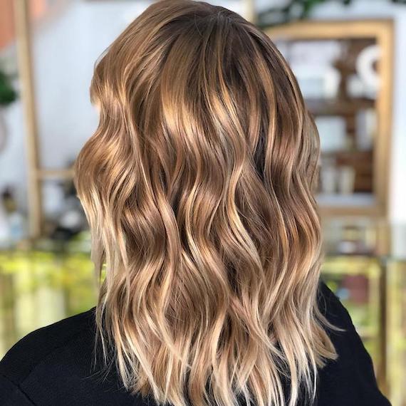 Back of woman’s head with blonde hair and brunette lowlights, created using Wella Professionals.
