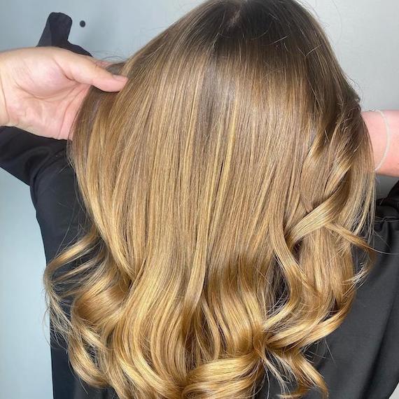 Image Credit: @black_diamond_by_jr Back of woman’s head with glossy bronde hair, created using Wella Professionals.