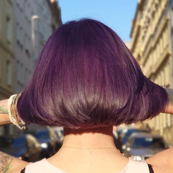 Back of woman’s head with short, dark purple hair, created using Wella Professionals.