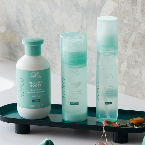 INVIGO Volume Boost Shampoo, Crystal Mask and Leave-In Spray in a bathroom.
