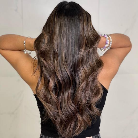 Back of woman’s head long, tousled, chocolate espresso brown hair.
