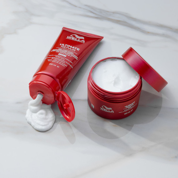 Der ULTIMATE REPAIR Conditioner und die ULTIMATE REPAIR Mask liegen auf einem weißen Marmorboden.