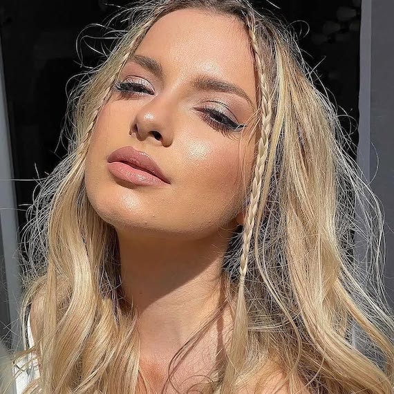 Model with long, tousled, golden blonde hair featuring micro braids through the front.