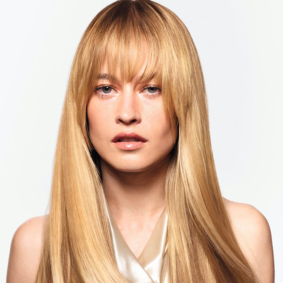 Model with long, ultra-shiny, honey blonde hair, featuring bangs.
