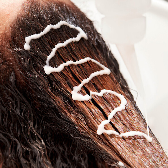 SHINEFINITY Color Glaze is applied to a model’s dark brown hair.
